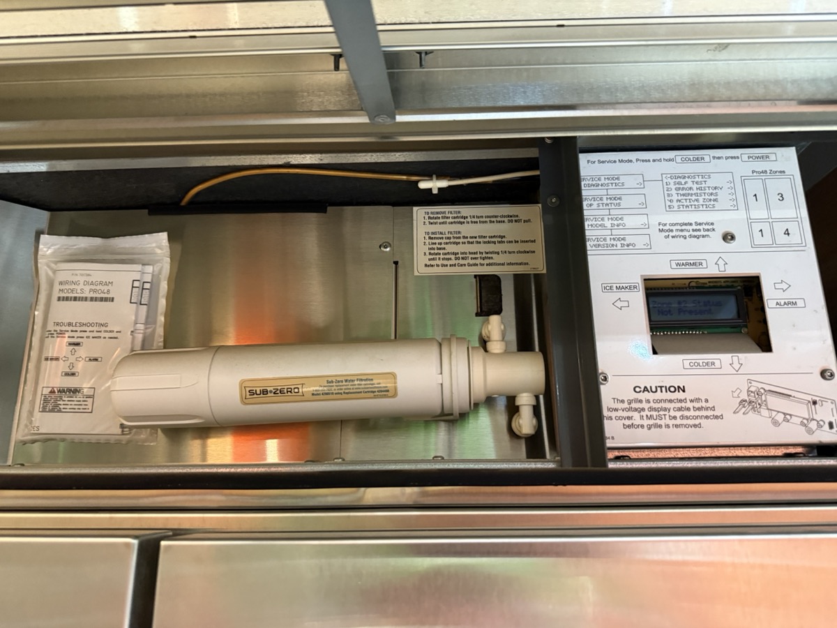 Sub-Zero PRO 48 冰箱頂部維修空間，可見原廠 Water FilterPro 濾芯與更換說明貼紙